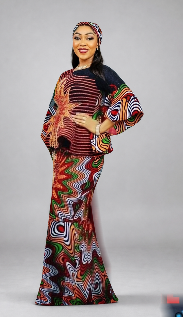 TL-branded background-edited portrait against a neutral grey studio background: a woman wearing a red, green and black patterned ensemble with flared sleeves and a matching headwrap